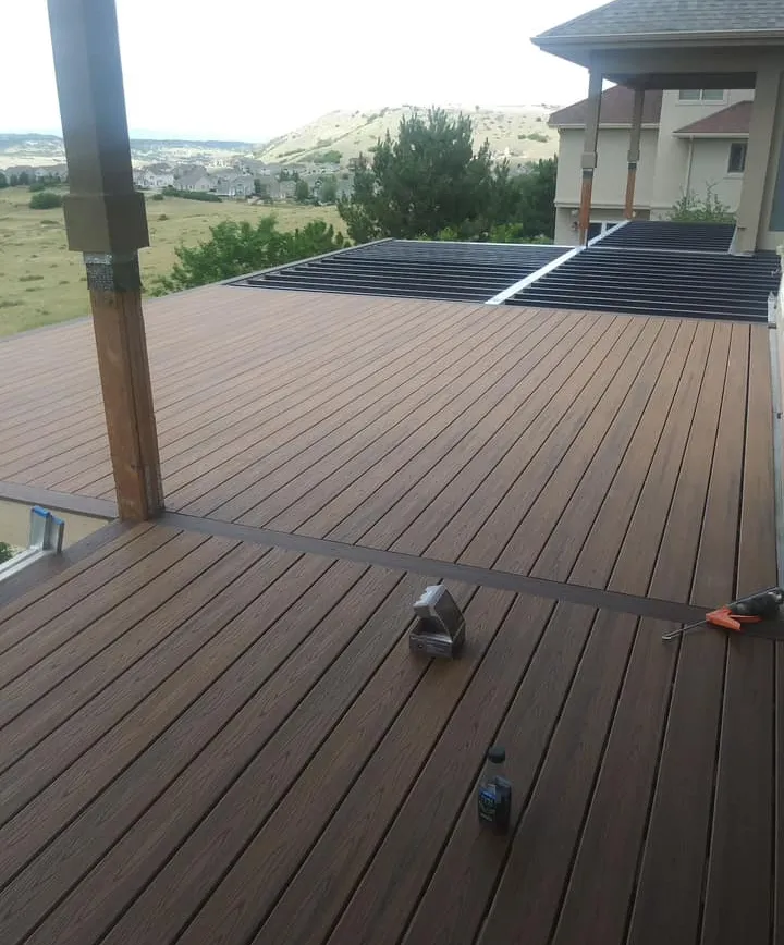 about-3 Spacious wooden deck with tools, overlooking a hilly landscape and nearby houses.