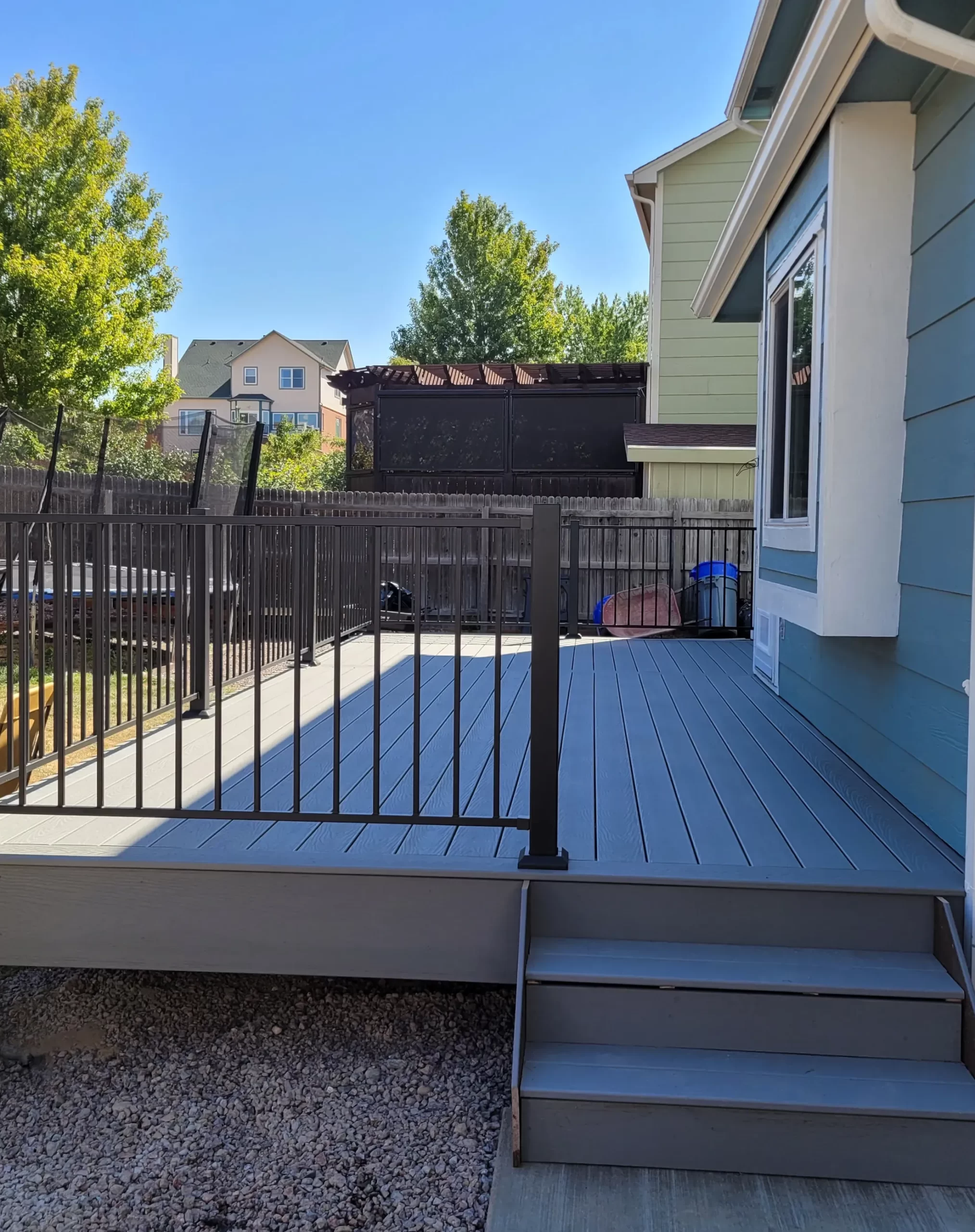 deck-construction-1 Deck Construction, Great Dane Construction, Front Range, CO: Wooden deck with metal railing leading to backyard; trees and houses in the background.
